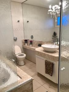 a bathroom with a sink and a toilet at Cobertura Beira Mar in Capão da Canoa