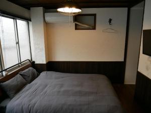 大阪的住宿－GUEST HOUSE KISHINOSATO，卧室配有一张床,墙上有灯