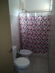 uma casa de banho com um WC e uma cortina de chuveiro em Helenita em Villa Mercedes