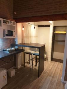 a kitchen with a counter and stools in a room at Finca El Amparo in Los Reartes