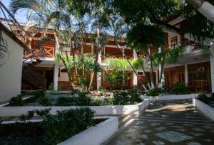 卡普兰干HOTEL BAHÍA PINORROA的一座带树木和植物庭院的建筑