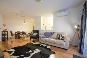 ein Wohnzimmer mit einem Sofa und einem Tisch in der Unterkunft Urban Escape – Strathfield in Sydney