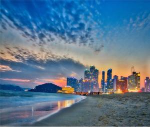 a view of a city from the beach at night at Hotel JUNE Haeundae in Busan