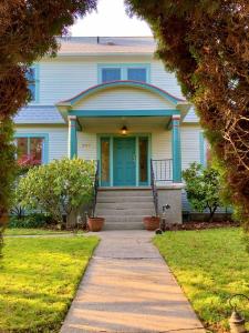 une maison avec une porte bleue et un trottoir dans l'établissement Riverpath Inn, à Eugene