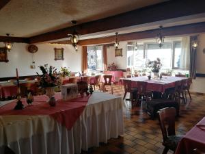 a restaurant with tables and chairs with red and white table cloth at Gasthaus Hochwald in Hattgenstein