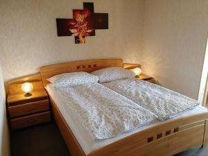 a bedroom with a bed with two night stands and two lamps at Gasthaus Hochwald in Hattgenstein