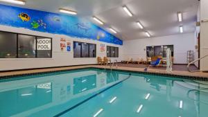 a swimming pool with blue water in a building at SureStay Hotel by Best Western Cedar Rapids in Cedar Rapids