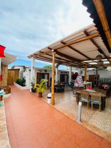 eine Terrasse mit Tischen und Stühlen unter einem Pavillon in der Unterkunft Zurisadai in Puerto Ayora