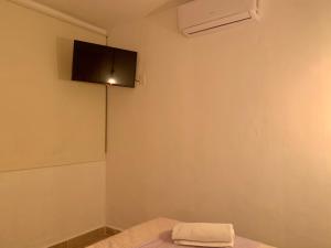 um quarto com uma televisão de ecrã plano na parede em Casa Delia Hotel Downtown em Bacalar