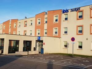 un bâtiment avec un panneau sur son côté dans l'établissement Ibis budget Verdun, à Verdun-sur-Meuse