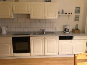 a kitchen with white cabinets and a sink at 50035.... in Altfunnixsiel