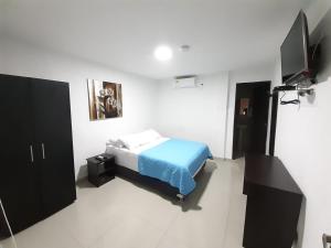 een slaapkamer met een bed en een flatscreen-tv bij Hotel Prado 53 in Barranquilla