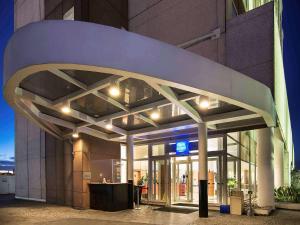 a lobby of a building with a lit up facade at ibis budget Tambore in Barueri