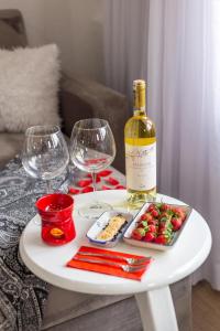 Sadaret Hotel&Suites Istanbul -Best Group Hotels في إسطنبول: طاولة بيضاء مع زجاجة من النبيذ وكؤوس من النبيذ