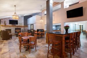 a dining room with tables and chairs and a fireplace at AmericInn by Wyndham Apple Valley in Apple Valley