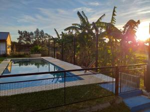 ein Pool in einem Garten mit einem Zaun in der Unterkunft Aitue Bungalows in Gualeguaychú + 25 Fotos