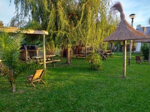 a park with benches and a picnic table and a tree at Aitue Bungalows in Gualeguaychú