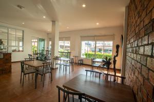 a restaurant with tables and chairs and windows at Sino Mansion in Ranong