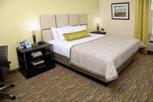 um quarto de hotel com uma cama grande e uma mesa de cabeceira em Candlewood Suites Oklahoma City - Bricktown, an IHG Hotel em Oklahoma City