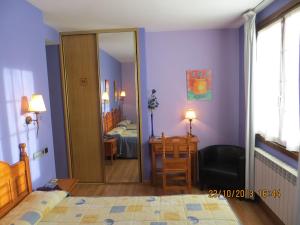 ein Zimmer mit einem Schlafzimmer mit lila Wänden und einem Spiegel in der Unterkunft Hotel Virginia R.H. in Vinuesa