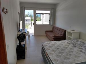 a living room with a bed and a couch at Apartamento Ilhas Moleques do Sul in Palhoça