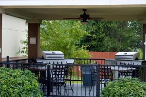 湄林的住宿－維多利亞燭木酒店，庭院设有2张烧烤桌椅