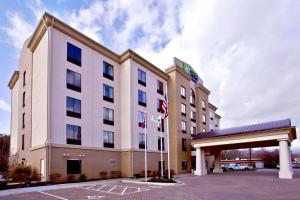un hotel con banderas frente a un edificio en Holiday Inn Express & Suites Oak Ridge, an IHG Hotel en Oak Ridge