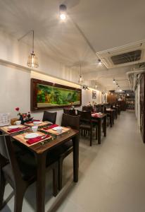 un comedor con mesas y sillas en un restaurante en Hanoi Exclusive Hotel, en Hanói