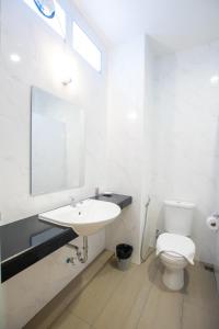 uma casa de banho branca com um lavatório e um WC em Sino Mansion em Ranong