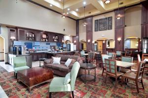 a living room with a couch and tables and chairs at Holiday Inn Express Hotel & Suites DFW West - Hurst, an IHG Hotel in Hurst