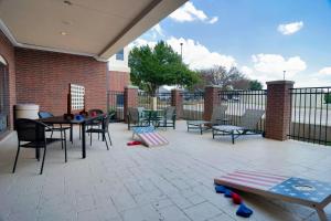 a patio with tables and chairs and a fence at Holiday Inn Express Hotel & Suites DFW West - Hurst, an IHG Hotel in Hurst