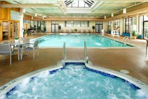 a pool in a hotel with a table and chairs at Holiday Inn Wilkes Barre - East Mountain, an IHG Hotel in Wilkes-Barre