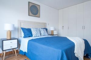 1 dormitorio con cama azul y mesita de noche en GLOBALSTAY Lux Apt Great Location GameRoom, en Lima