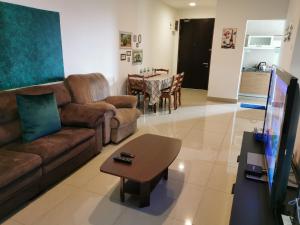 a living room with a couch and a table at Residence @ Shaftsbury Cyberjaya in Cyberjaya