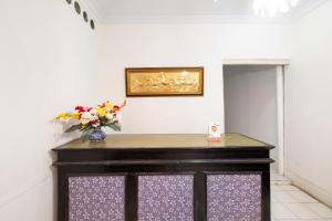 una stanza con un tavolo e un vaso di fiori di OYO 2394 Hotel Brosta a Yogyakarta