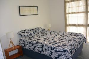 a bedroom with a bed with a black and white comforter at Alicante in Point Lookout