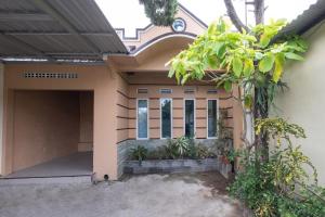 een huis met een poort en een garage bij OYO 2394 Hotel Brosta in Yogyakarta