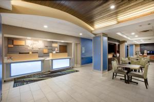 an office lobby with a table and chairs at Holiday Inn Express Hotel & Suites Columbus, an IHG Hotel in Columbus