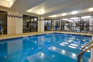 ein großer Pool mit blauem Wasser in einem Gebäude in der Unterkunft Holiday Inn Express Hotel & Suites Meadowlands Area, an IHG Hotel in Carlstadt