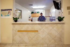 un hombre está parado en un mostrador en una farmacia en Candlewood Suites Corpus Christi-SPID, an IHG Hotel, en Corpus Christi