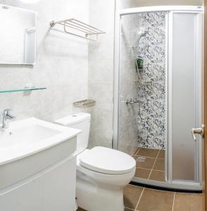 een witte badkamer met een toilet en een douche bij ioio in Tainan