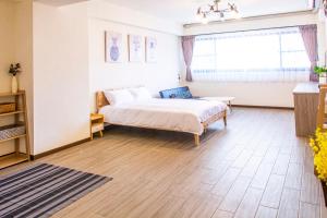 a bedroom with a bed and a large window at ioio in Tainan
