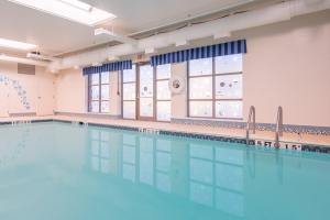 a large swimming pool in a room with a large window at Holiday Inn Express Cambridge by IHG in Cambridge