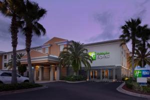 ジャクソンビル・ビーチにあるHoliday Inn Express Jacksonville Beach, an IHG Hotelのヤシの木が立ち並ぶ建物