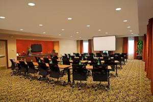 a conference room with tables and chairs and a white screen at Staybridge Suites Chantilly Dulles Airport by IHG in Chantilly