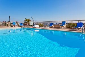 una grande piscina con sedie e sedie blu di Holiday Inn Charleston-Riverview, an IHG Hotel a Charleston