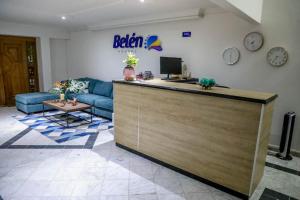 a lobby with a reception counter and a couch at HOTEL BELEN-La Flora- Cali Valle del Cauca in Cali