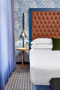 a bedroom with a bed with a headboard and a table at Kimpton Hotel Monaco Denver by IHG in Denver