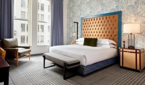 a bedroom with a large bed and a chair at Kimpton Hotel Monaco Denver by IHG in Denver