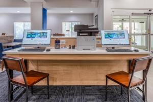a desk with three computers on top of it at Holiday Inn Express Arrowood by IHG in Charlotte